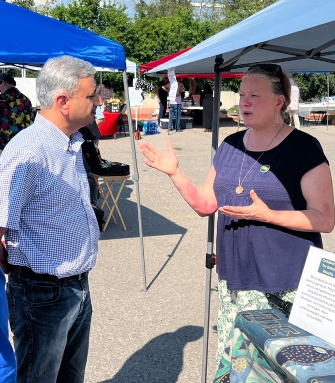 Naeem Awan listening to a resident at a community event in Cambridge