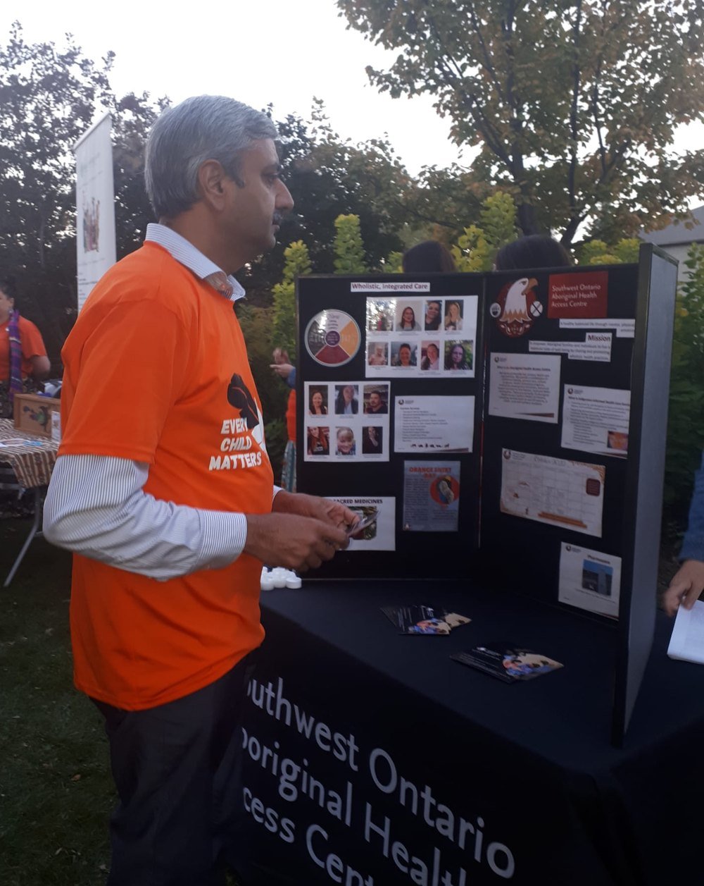 Naeem Awan wearing an Every Child Matters shirt at an Orange Shirt Day community event